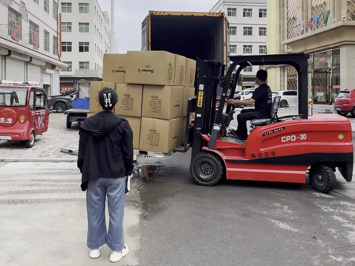 Forklift loading backpack cartons into export container